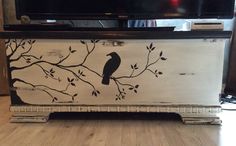 a tv stand with a bird painted on it