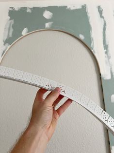 a person holding up a white tape with holes in it