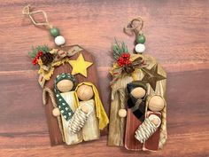 two wooden ornaments are hanging on a wood surface, one is holding a star and the other has a wreath