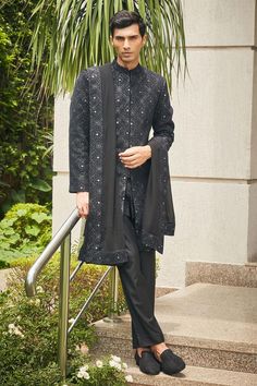 Black sherwani with floral Mughal chikankari embroidery and sequin highlights. Comes with matching dupatta, short kurta and pant.
Components: 4
Pattern: Embroidered
Type Of Work: Chikankari, Sequins
Neckline: Mandarin
Sleeve Type: Straight Full
Fabric: Sherwani and Dupatta- Georgette, Kurta and Pant- Terrywool
Color: Black
Other Details: 
Model height: 6ft, wearing size M
Occasion: Cocktail and Reception - Aza Fashions Black Sherwani, Kurta Set Men, Georgette Kurta, Chikankari Embroidery, Kurta Set For Men, Short Kurta, Types Of Work, Kurta With Pants, Kurta Set