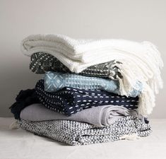 a pile of folded clothes sitting on top of each other