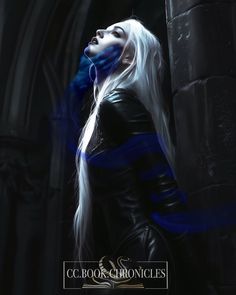 a woman with long white hair and blue eyes standing in front of a gothic castle