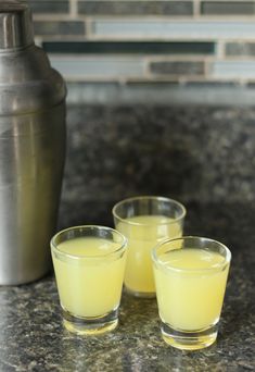 three shot glasses sitting on top of a counter