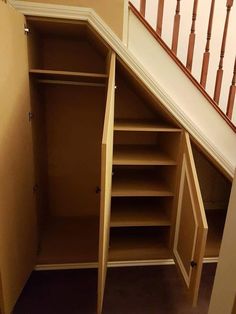 an empty closet under the stairs in a house