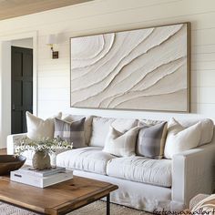 a living room filled with furniture and a painting on the wall