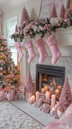 pink christmas decorations with stockings and candles in front of a fireplace decorated for the holidays