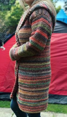 a woman standing in front of a tent with her hands on her hips and looking at the camera