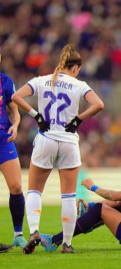 two female soccer players are on the field