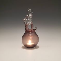 a small glass vase with a candle in it