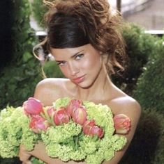 a beautiful young woman holding a bouquet of flowers