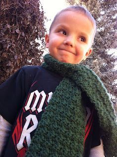 a young boy wearing a green knitted scarf