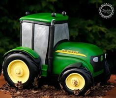 there is a green toy tractor on the ground with trees in the backgroud