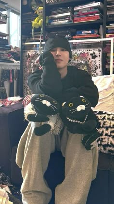 a person sitting on the floor with two stuffed animals in front of their legs and arms