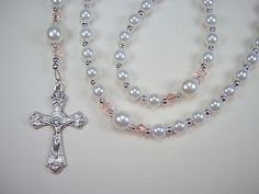 "Great Gift This Beautiful Rosary is handcrafted with 6mm  and 8mm White Czech Glass Pearl Beads.   Genuine Czech Glass Pearl Beads.  4mm Pale Pink Diamond Shaped Bicone Glass Beads.  The Rosary is 16 3/4\" from top of the Loop to bottom of Cross. ( Laid flat )  Leaf Sunburst Crucifix  This Beautifully made Rosary Crucifix features a Sunburst behind  Jesus and Detailed Images on all 4 Corners.  Made in Italy, 1 1/2\" long and silver oxidized. Madonna and Jesus Rosary Center Piece This center pie White Rosary, Blue Rosary, Catholic Necklace, Crucifix Necklace, Rosary Catholic, Onyx Bead, Beading Wire, Pink Diamond, Czech Glass Beads