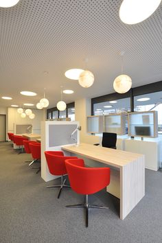 an empty office with red chairs and desks