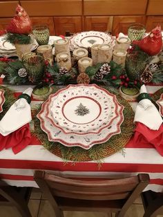 a christmas table setting with pine cones and candles