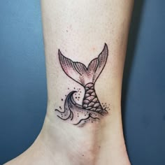 a small mermaid tail tattoo on the ankle