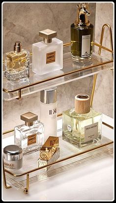 three glass shelves with perfume bottles on them