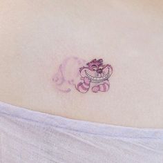 a small tattoo on the back of a woman's upper arm, with pink ink