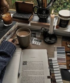 an open book sitting on top of a table next to a cup of coffee