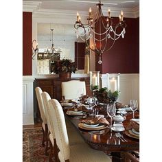 the dining room table is set with place settings for six people and candles are lit