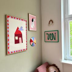 a child's room with pictures on the wall and a stuffed animal sitting next to it