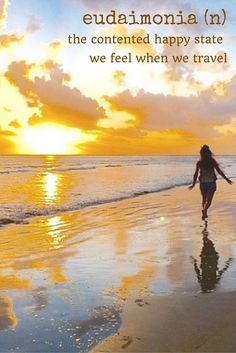 a woman walking on the beach at sunset