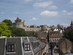 a city with lots of tall buildings next to it's walls and trees in the foreground