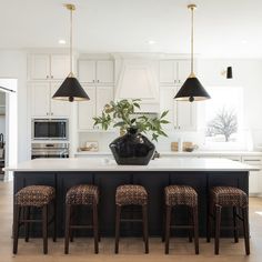 a kitchen island with four stools in front of it