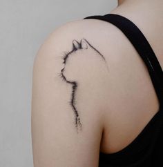 a woman's shoulder with a cat tattoo on it