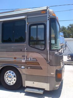 an rv parked in a parking lot next to power lines