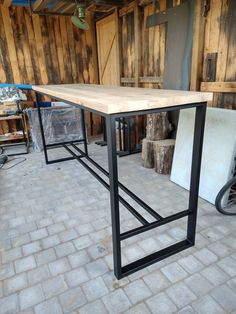 a wooden table sitting on top of a brick floor