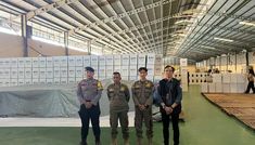 three men standing next to each other in a warehouse