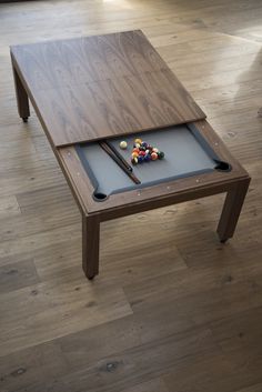 a pool table with two cues and balls on it in the middle of a living room