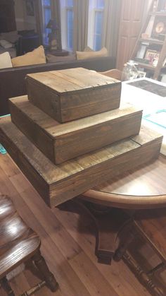 three pieces of wood stacked on top of each other in front of a table with chairs