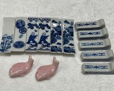 five pieces of blue and white porcelain sitting next to each other on a tablecloth