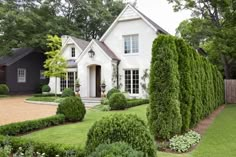 a white house surrounded by lush green bushes