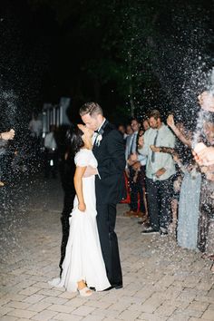 a newly married couple kissing under confetti