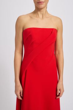 the woman is wearing a red dress with an asymmetrical design on it