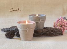 two candles sitting next to each other on top of a white cloth covered tablecloth