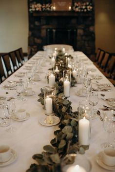 a long table is set with candles and place settings for dinner guests to sit at