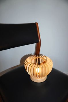 cordless wooden style table lamp sitting on a black chair