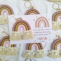 several key chains with tassels hanging from them on a white table cloth covered background