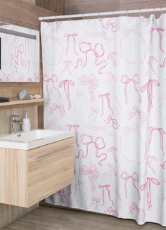 a pink and white shower curtain in a bathroom next to a sink with a mirror