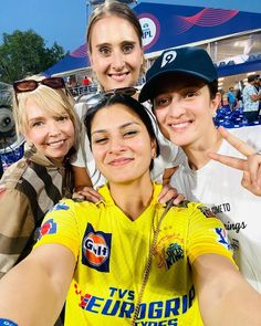 three women taking a selfie in front of a stadium