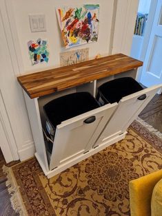 a white cabinet with two black bins underneath it