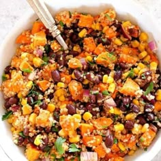 a white bowl filled with black beans, corn and quinoa salad on top of a checkered table cloth