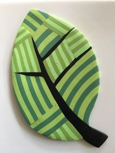 a green and black paper plate with a tree on it