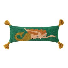 a green pillow with a lion on it's back and tassels around the edges