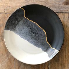 a black and white plate sitting on top of a wooden table